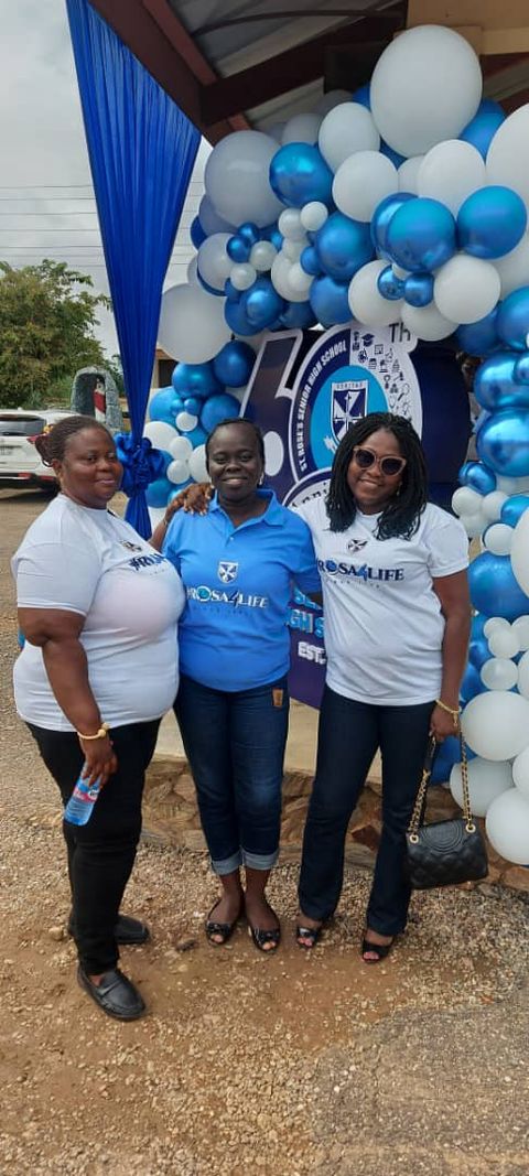 Three friends by the balloon arch